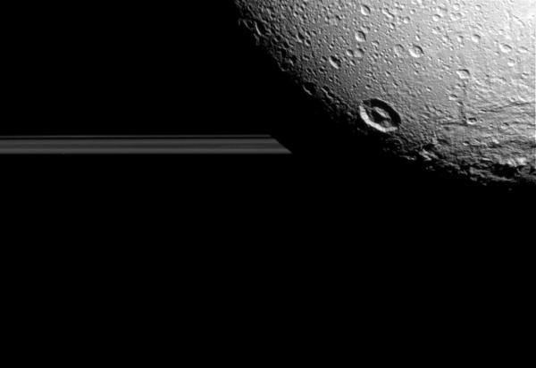 Dione's night side blocks the view of Saturn's rings, seen edge-on as Cassini approached the moon on Aug. 17, 2015.